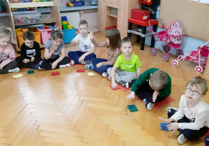 Dzieci wystukują rytm piosenki na woreczkach.